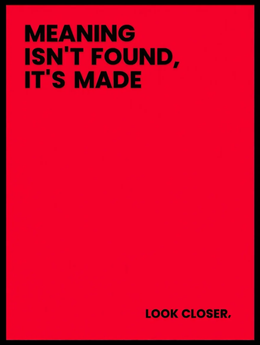 A minimalist typographic poster design featuring bold black sans-serif text against a solid red background, framed in black. The main text reads "MEANING ISN'T FOUND, IT'S MADE" with strategic hyphenation, while smaller text at the bottom states "LOOK CLOSER."  The composition creates a striking visual hierarchy through size contrast and spatial arrangement of the text elements.